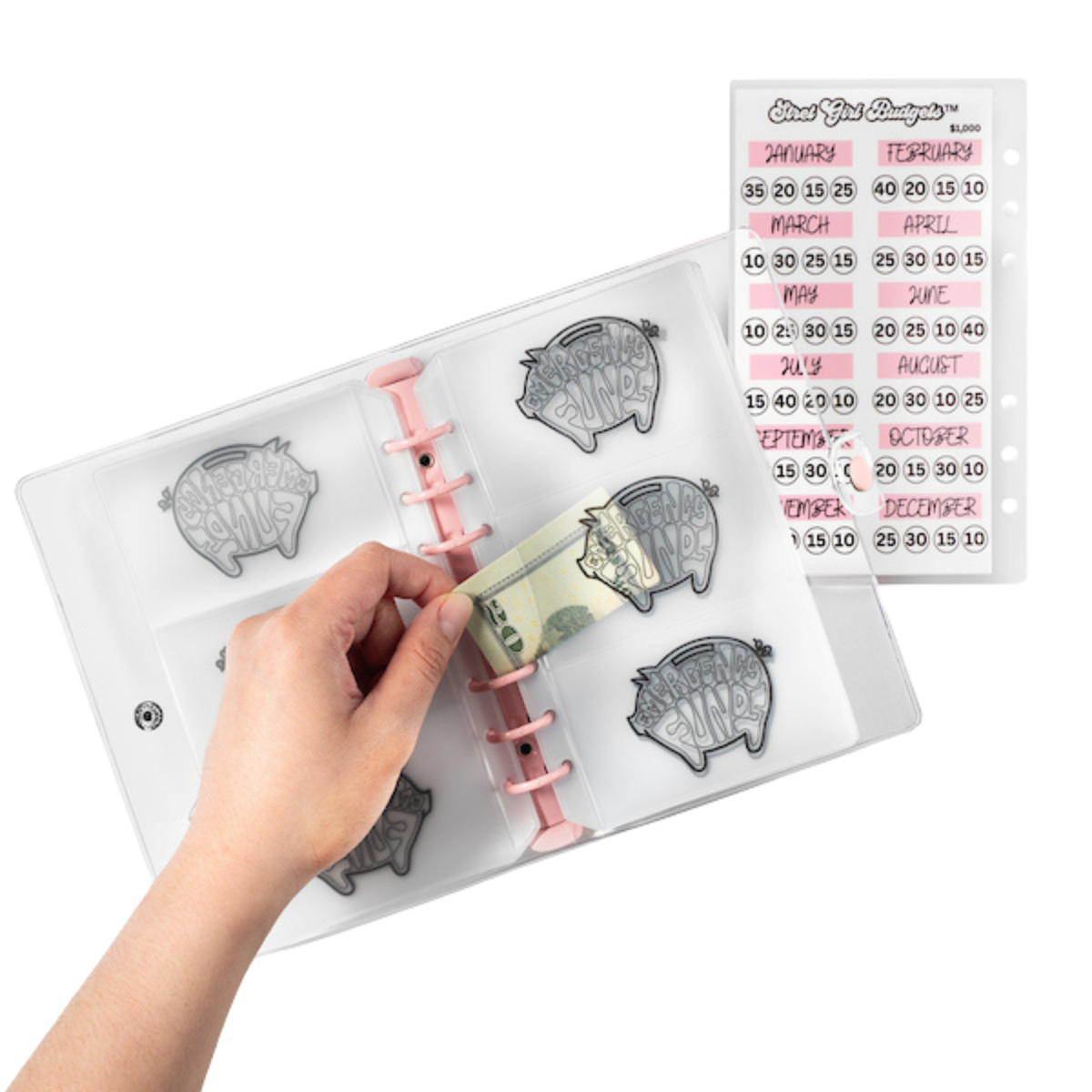 Hand holding a money holder with piggy bank design, surrounded by clear stamp sets on a white background.