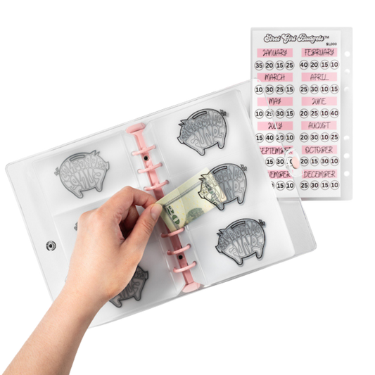 Hand holding a money holder with piggy bank design, surrounded by clear stamp sets on a white background.